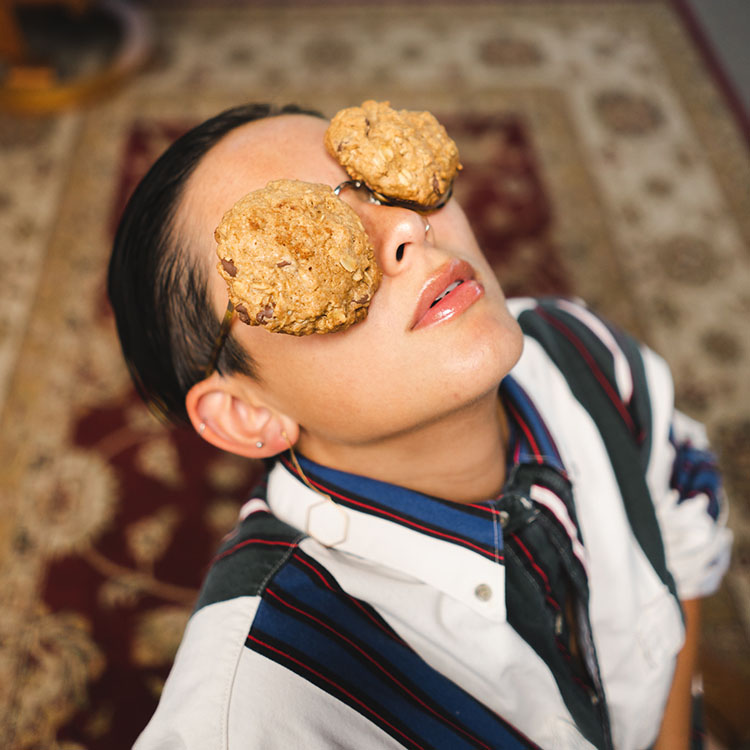 Woman with chocolate chip cookies on her eyes